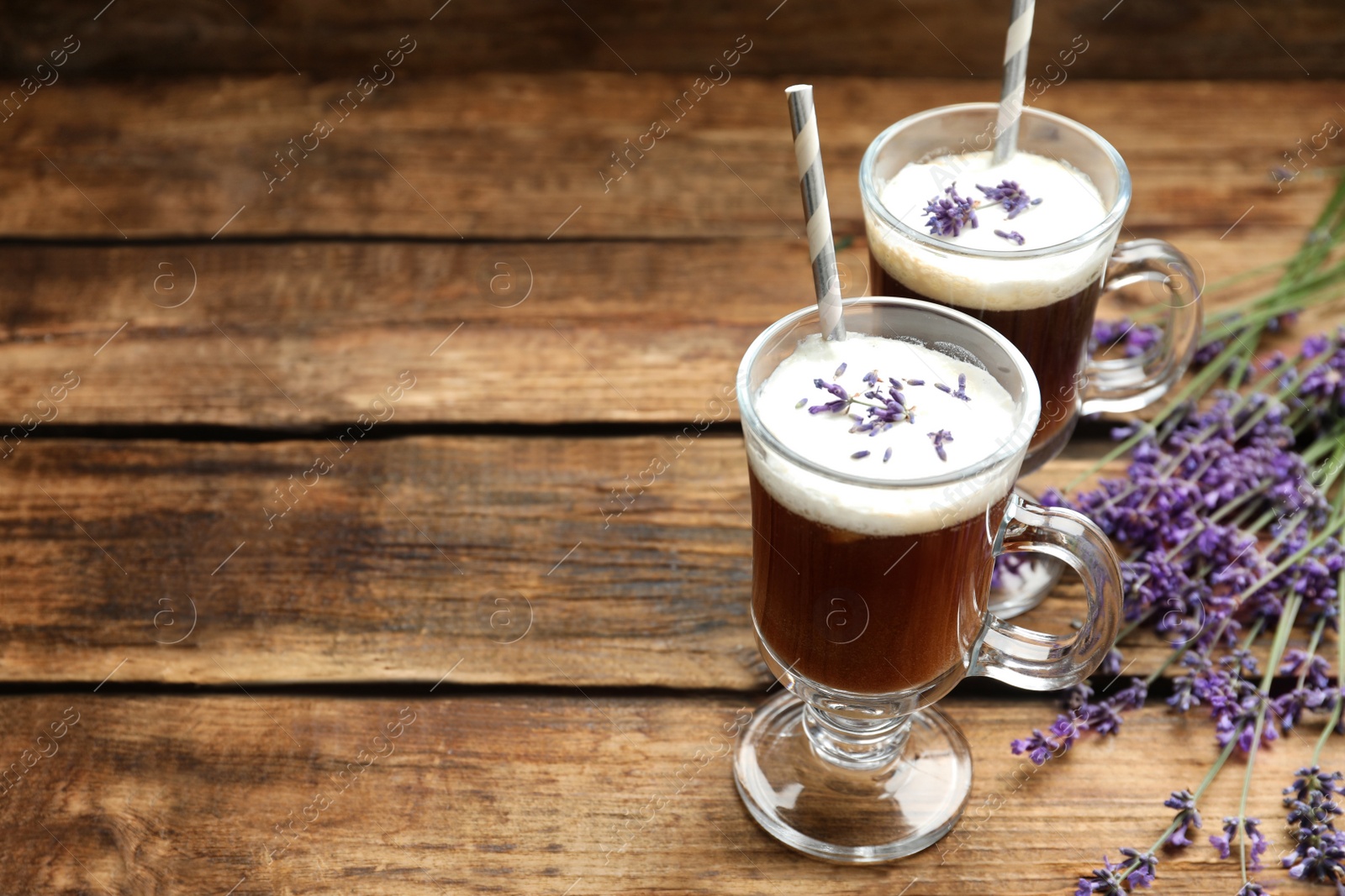 Photo of Delicious coffee with lavender on wooden table. Space for text