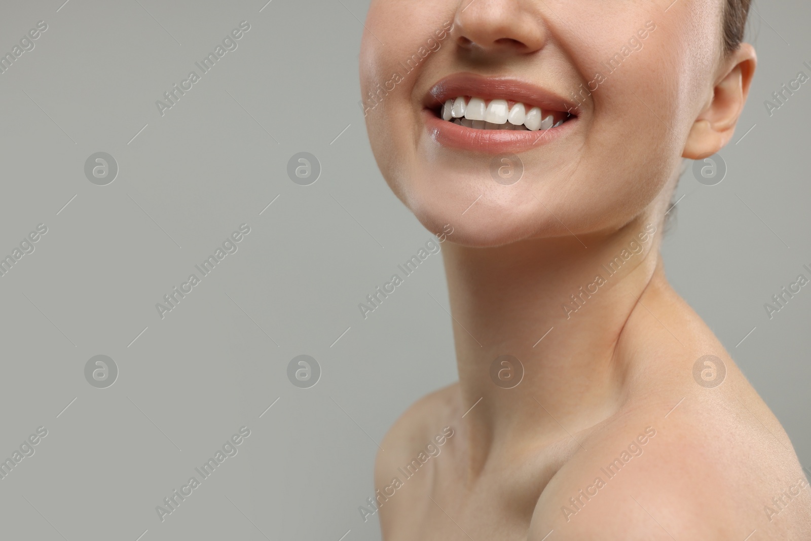 Photo of Beauty concept. Smiling woman on grey background, closeup. Space for text
