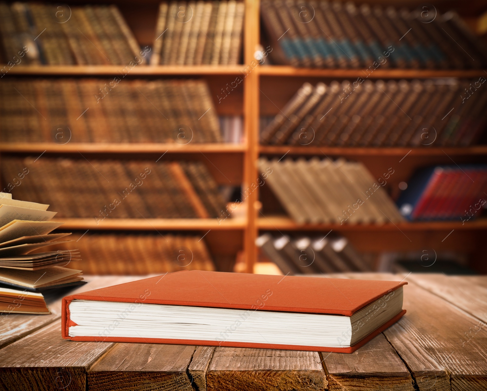 Image of Book with red cover on wooden table in library