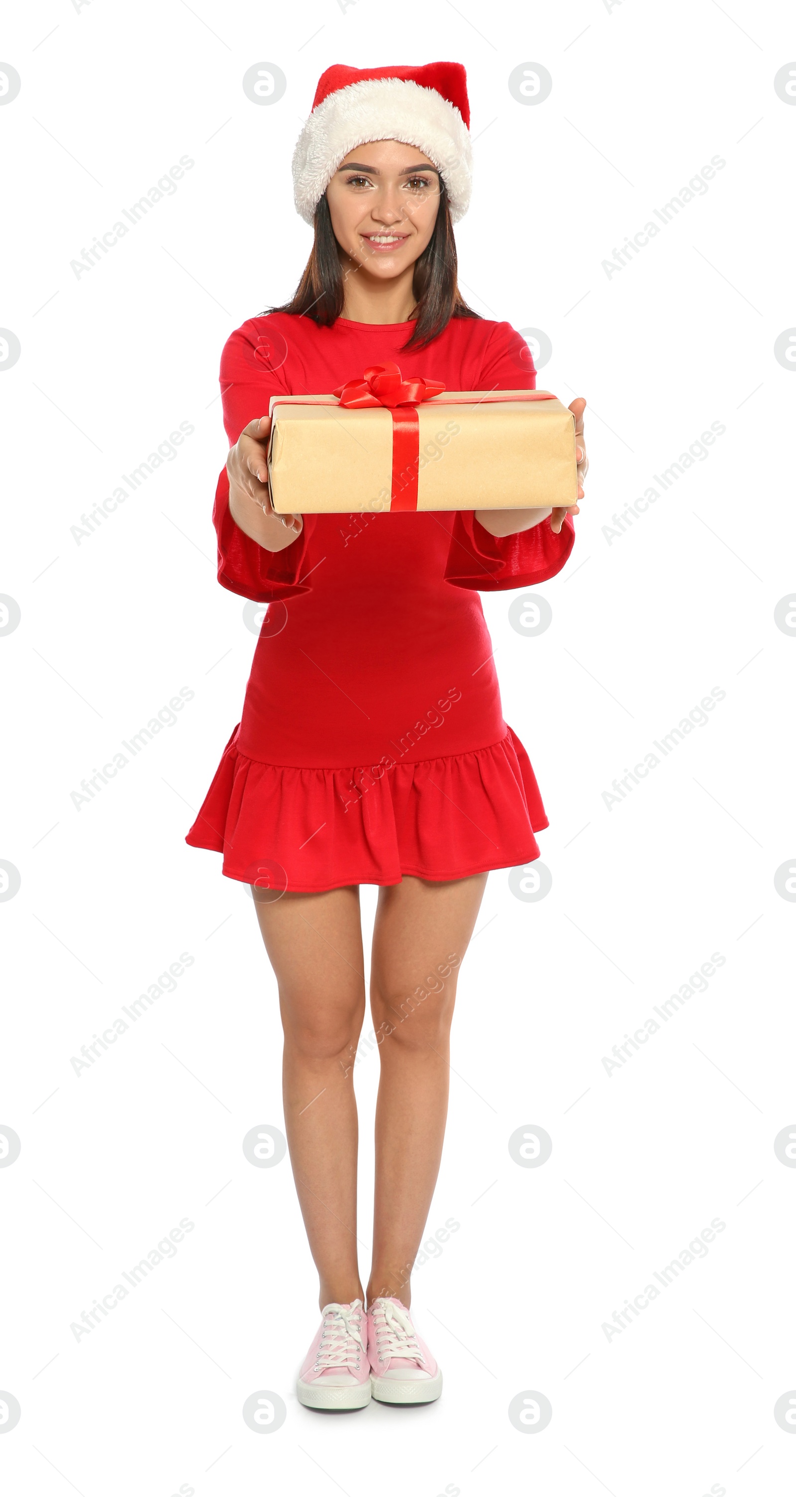 Photo of Young happy woman with Santa hat and gift box on white background. Christmas celebration