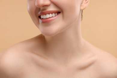 Photo of Beauty concept. Smiling woman on beige background, closeup