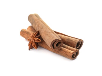 Photo of Aromatic cinnamon sticks and anise on white background