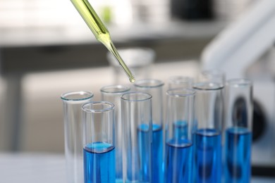 Photo of Laboratory analysis. Dripping liquid into test tubes indoors, closeup