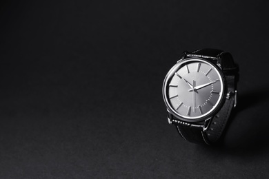 Photo of Luxury wrist watch on black background, space for text