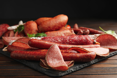 Photo of Different tasty sausages on wooden table, closeup