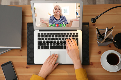 Image of Young woman having video chat with her grandmother at home, top view