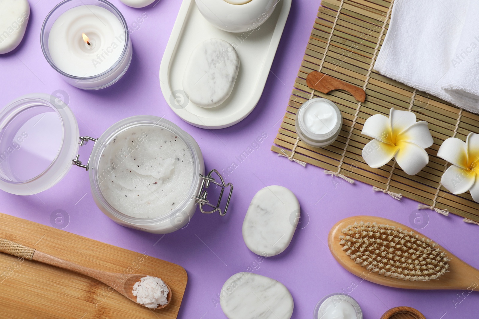 Photo of Flat lay composition with body scrub and spa stones on violet background