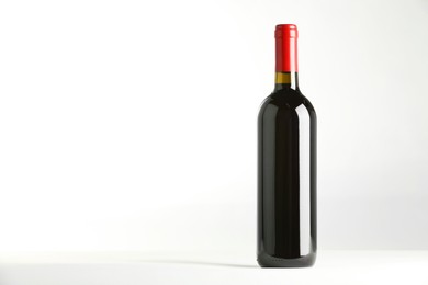 Photo of Bottle of expensive red wine on white background. Space for text