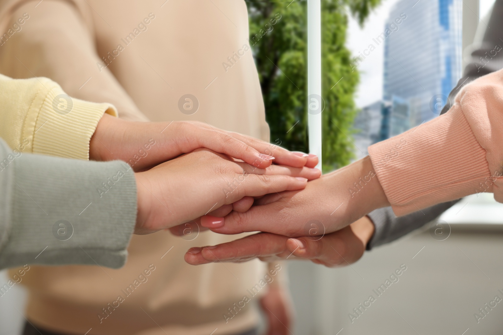 Photo of Group of people holding hands together indoors, closeup. Unity concept