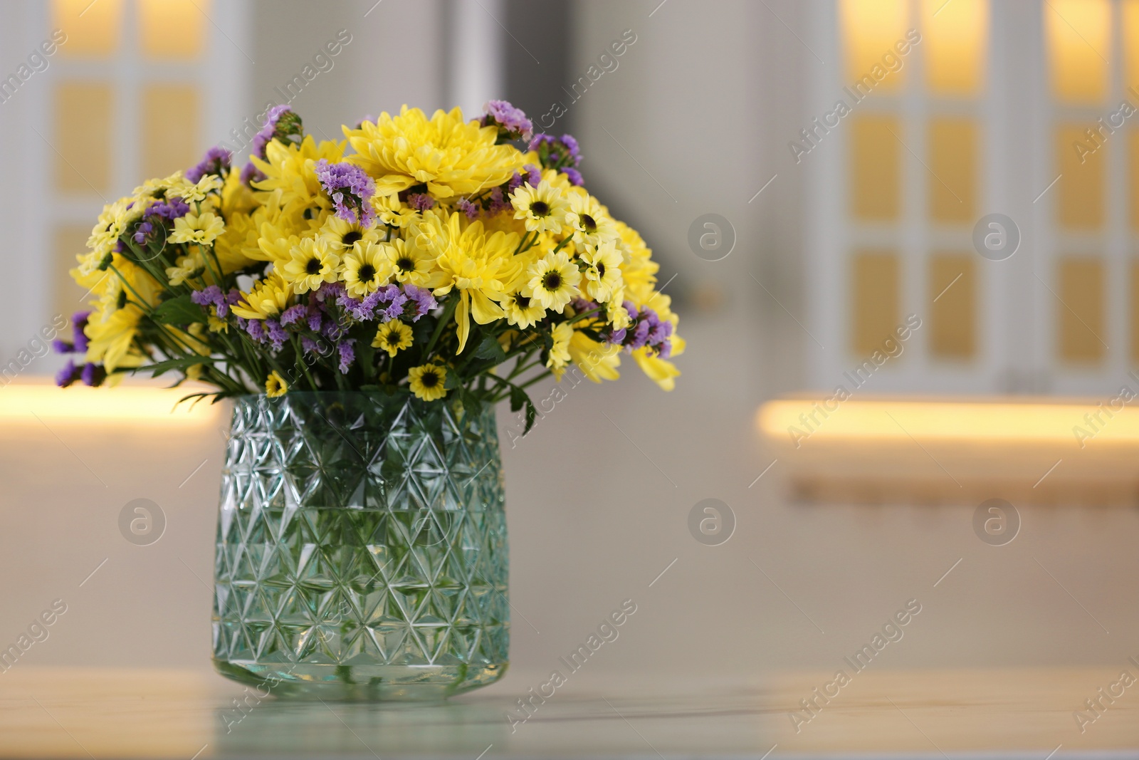 Photo of Vase with beautiful chrysanthemum flowers on table in kitchen, space for text. Interior design