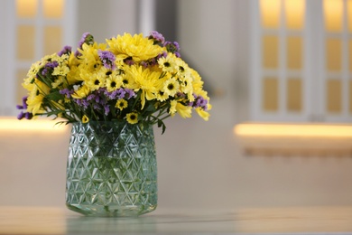 Vase with beautiful chrysanthemum flowers on table in kitchen, space for text. Interior design