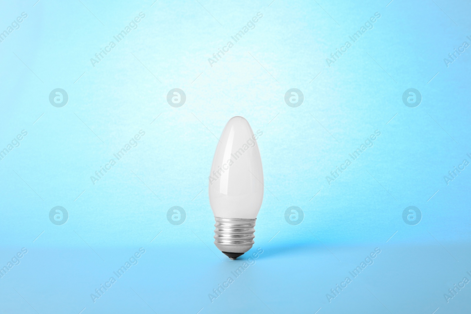 Photo of New modern lamp bulb on light blue background