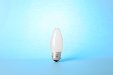 Photo of New modern lamp bulb on light blue background