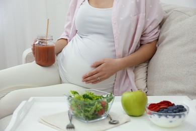 Photo of Pregnant woman eating breakfast at home, closeup. Healthy diet