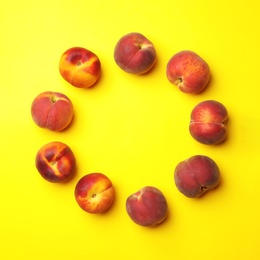 Photo of Flat lay composition with ripe peaches on yellow background, space for text