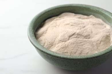 Photo of Bowl of agar-agar powder on white table, closeup