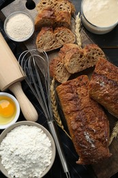 Photo of Flat lay composition with freshly baked bread and sourdough on wooden table