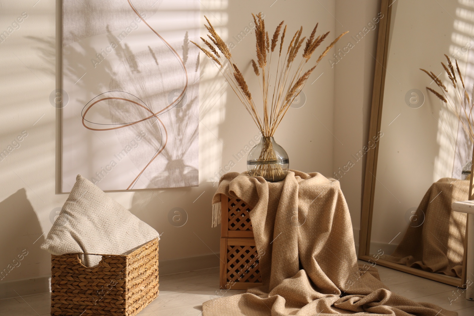 Photo of Vase with decorative dried plants and painting in stylish room interior