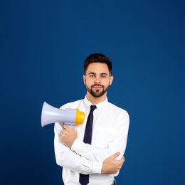 Photo of Young man with megaphone on blue background