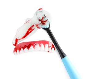 Photo of Teeth cover and brush with blood on white background, top view. Gum problems