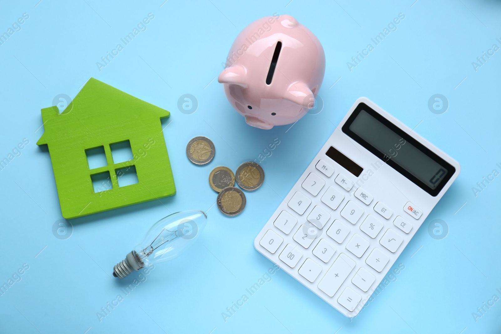 Photo of Flat lay composition with piggy bank and calculator on light blue background