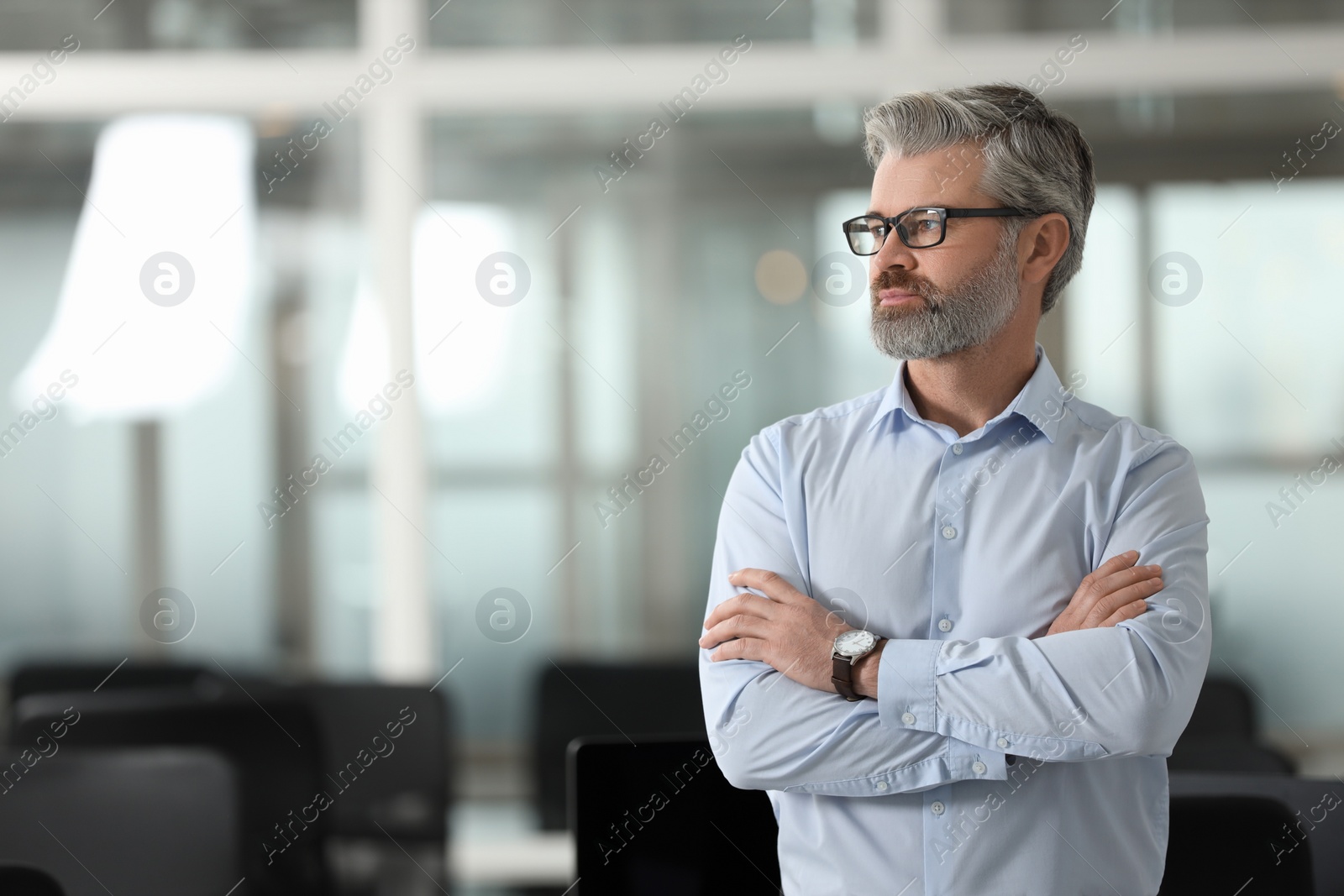 Photo of Handsome man with crossed arms in office, space for text. Lawyer, businessman, accountant or manager