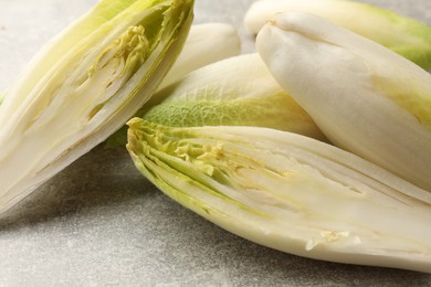 Photo of Fresh raw Belgian endives (chicory) on light grey table, closeup