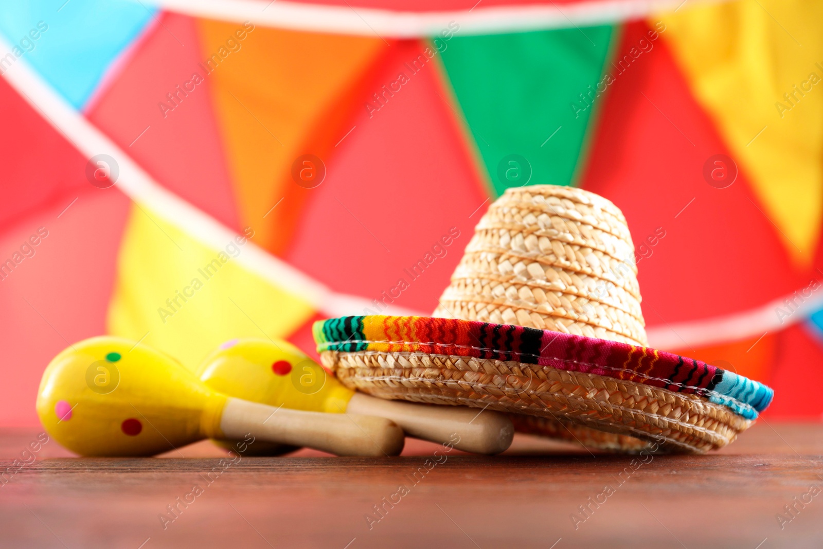 Photo of Mexican sombrero hat and maracas on wooden table