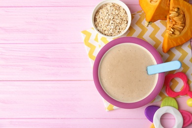 Flat lay composition with plate of healthy baby food and space for text on color background