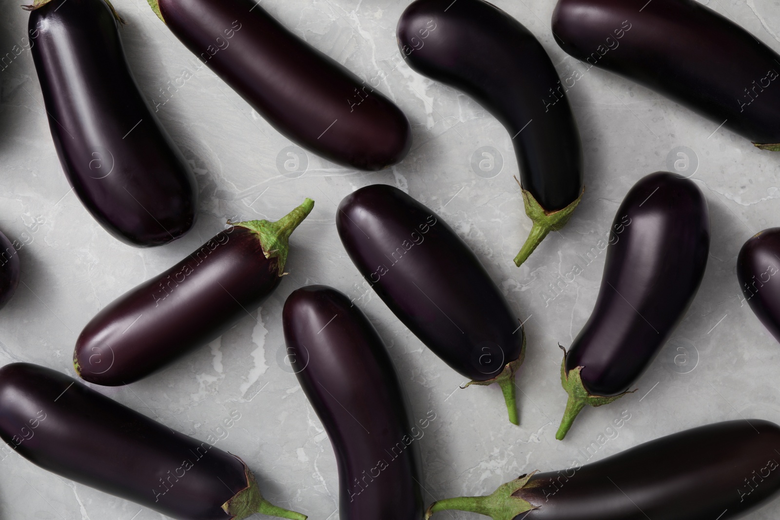Photo of Raw ripe eggplants on grey table, flat lay