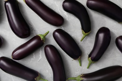 Raw ripe eggplants on grey table, flat lay