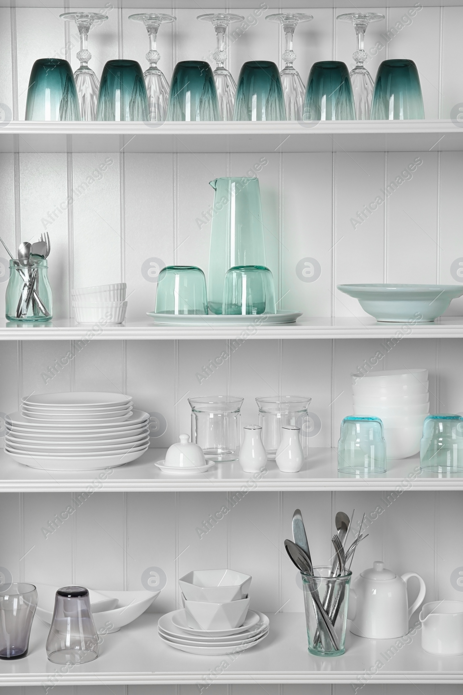 Photo of White shelving unit with set of dishware