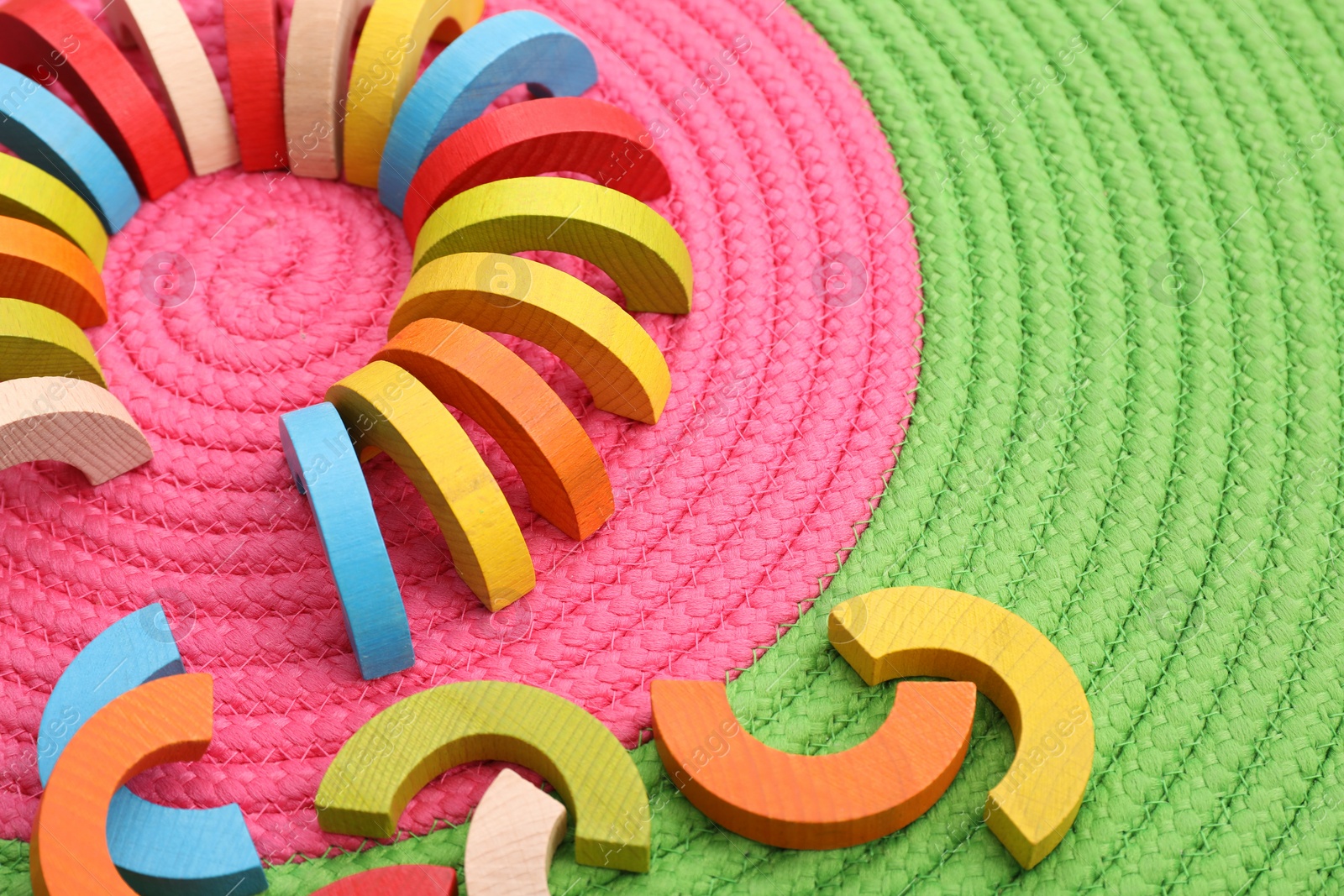 Photo of Colorful wooden pieces of playing set on color mat, space for text. Motor skills development