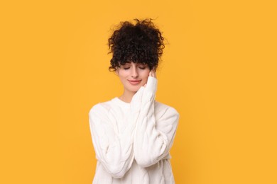 Photo of Young woman in stylish white sweater on yellow background