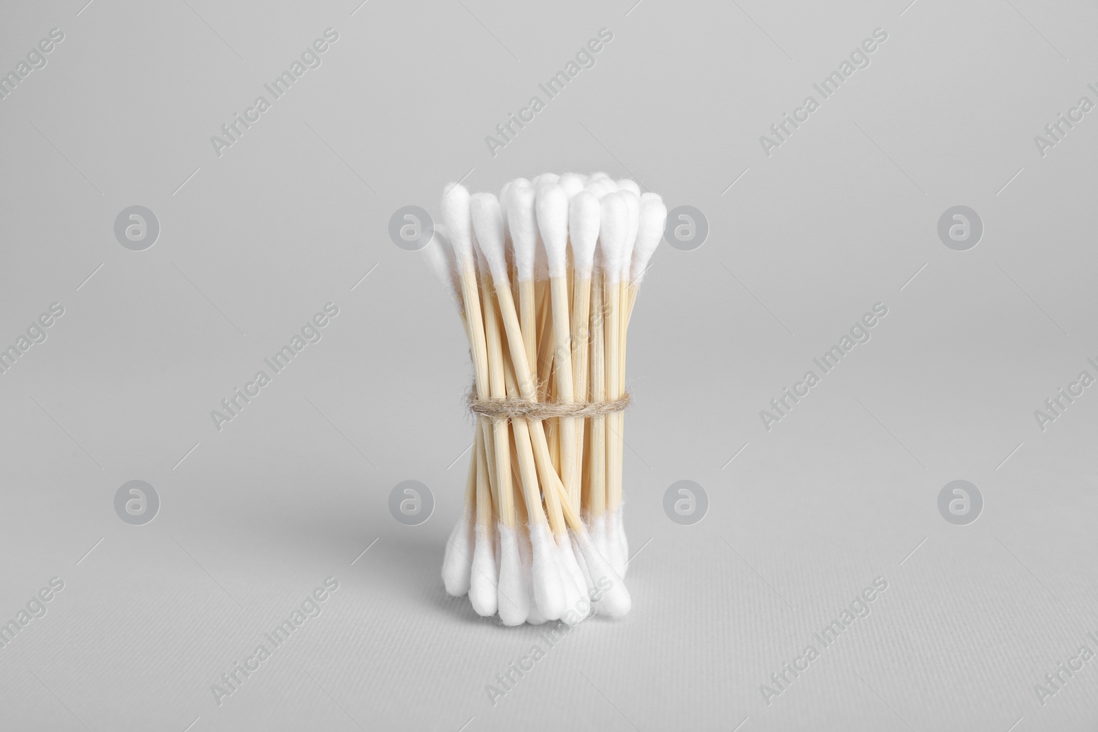 Photo of Bunch of wooden cotton buds on light grey background