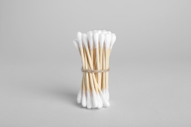 Photo of Bunch of wooden cotton buds on light grey background