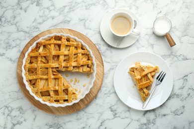 Tasty homemade quince pie served on white marble table, flat lay