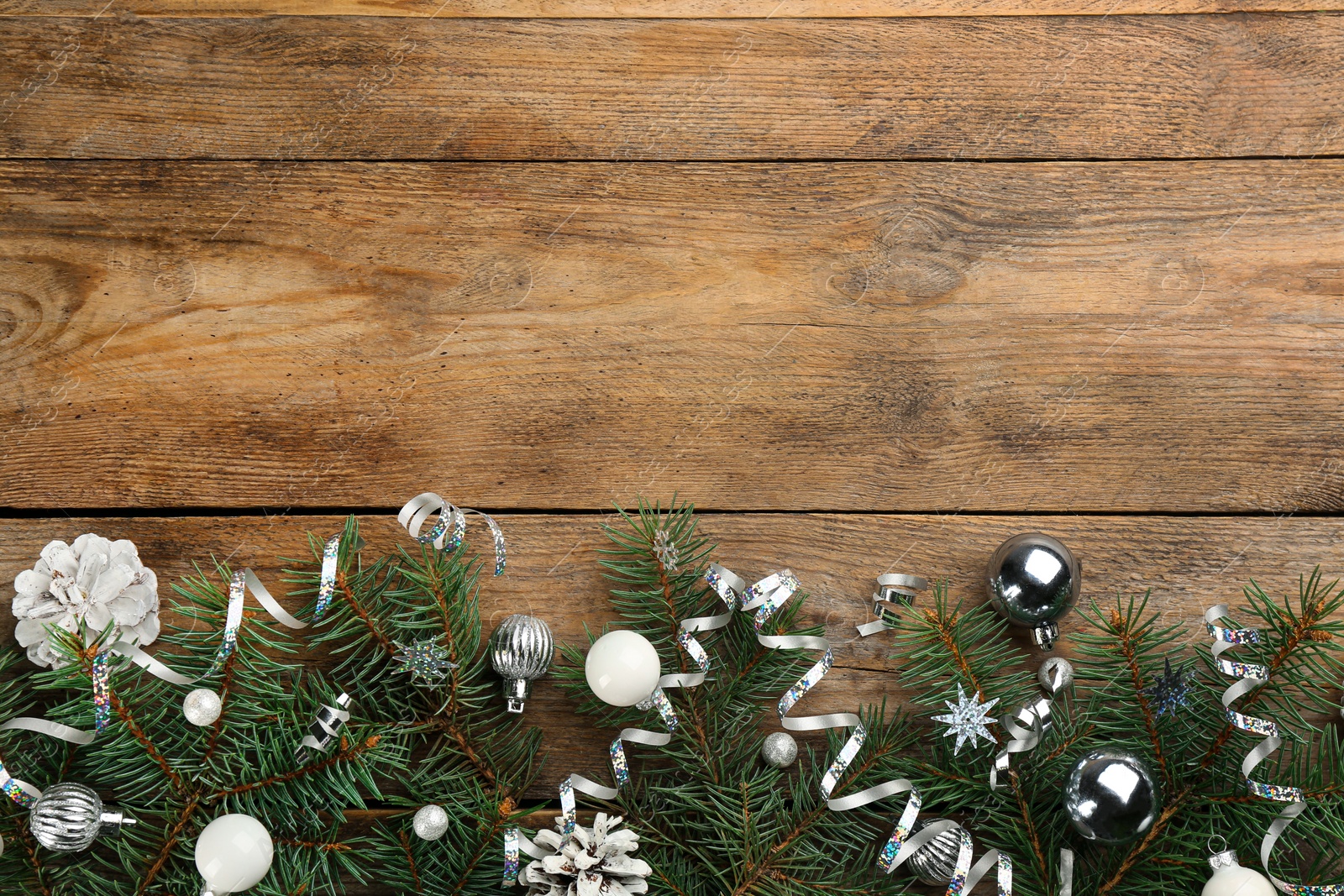 Photo of Flat lay composition with serpentine streamers and Christmas decor on wooden background. Space for text