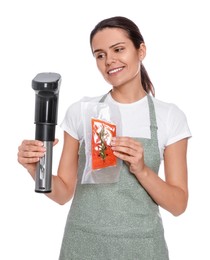 Beautiful young woman holding sous vide cooker and salmon in vacuum pack on white background