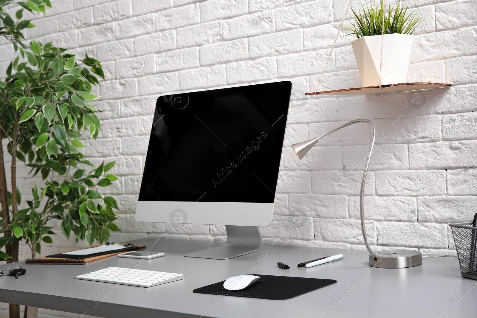 Photo of Interior of comfortable work place with computer on table at home