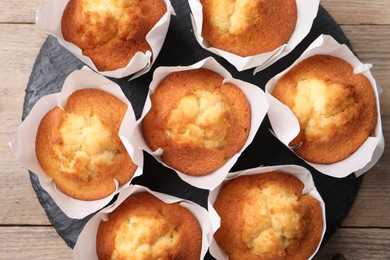 Delicious sweet muffins on wooden table, top view