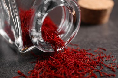 Photo of Aromatic saffron and glass jar on gray table, closeup