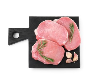 Photo of Black wooden board with pieces of raw pork meat, garlic and rosemary isolated on white, top view