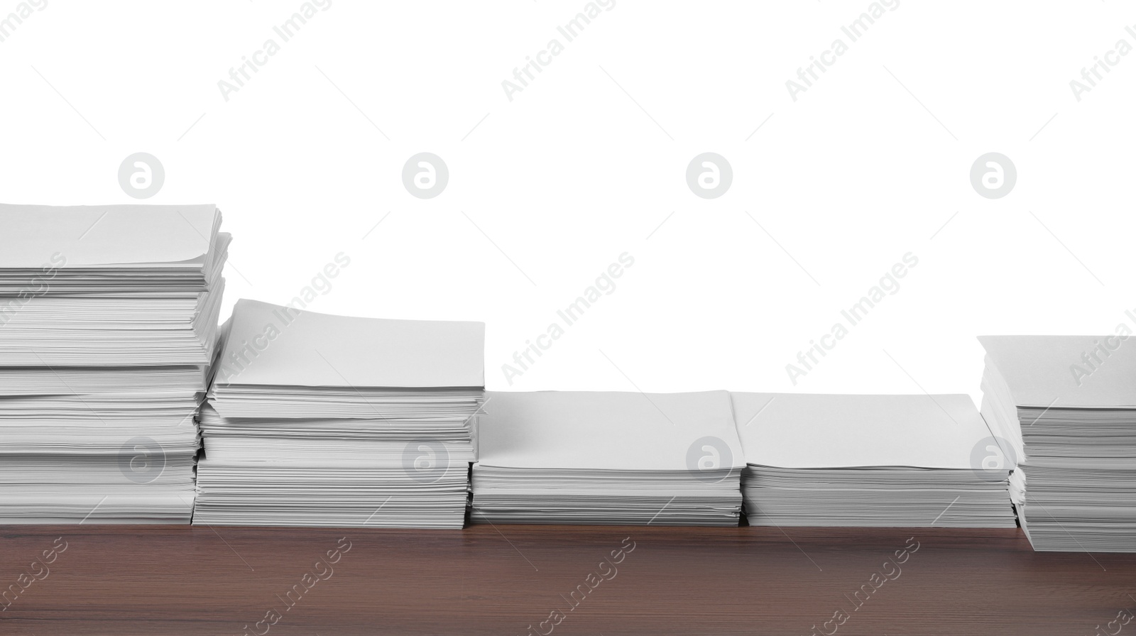 Photo of Stacks of paper sheets on wooden table against white background