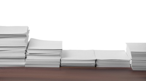 Stacks of paper sheets on wooden table against white background