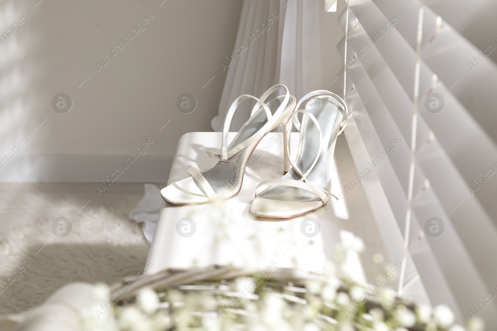 Photo of Beautiful wedding shoes on window sill indoors
