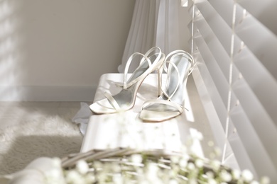 Beautiful wedding shoes on window sill indoors