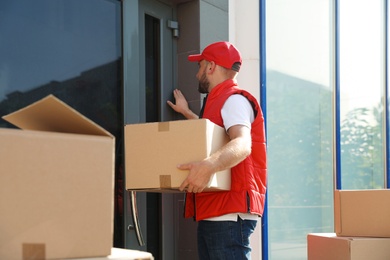 Photo of Male mover with parcel box near entrance