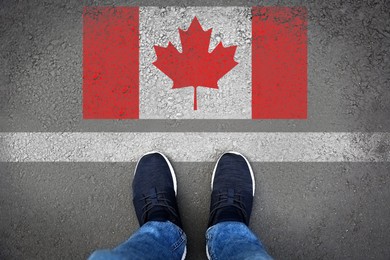 Image of Immigration. Man standing on asphalt near flag of Canada, top view