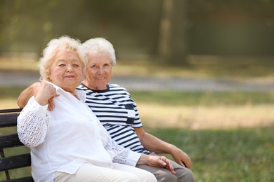 Photo of Elderly women resting on bench in park